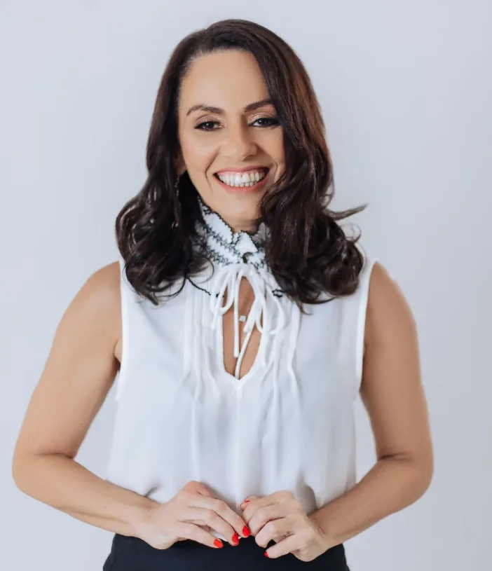 Fátima Pessoa, fonoaudióloga, sorrindo, de blusa branca